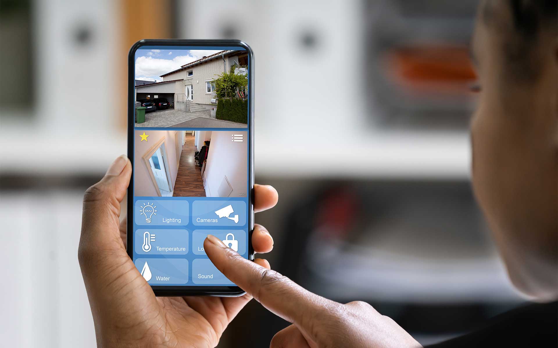 Woman viewing a smart home security app on a mobile phone, showing CCTV views of interior and exterior