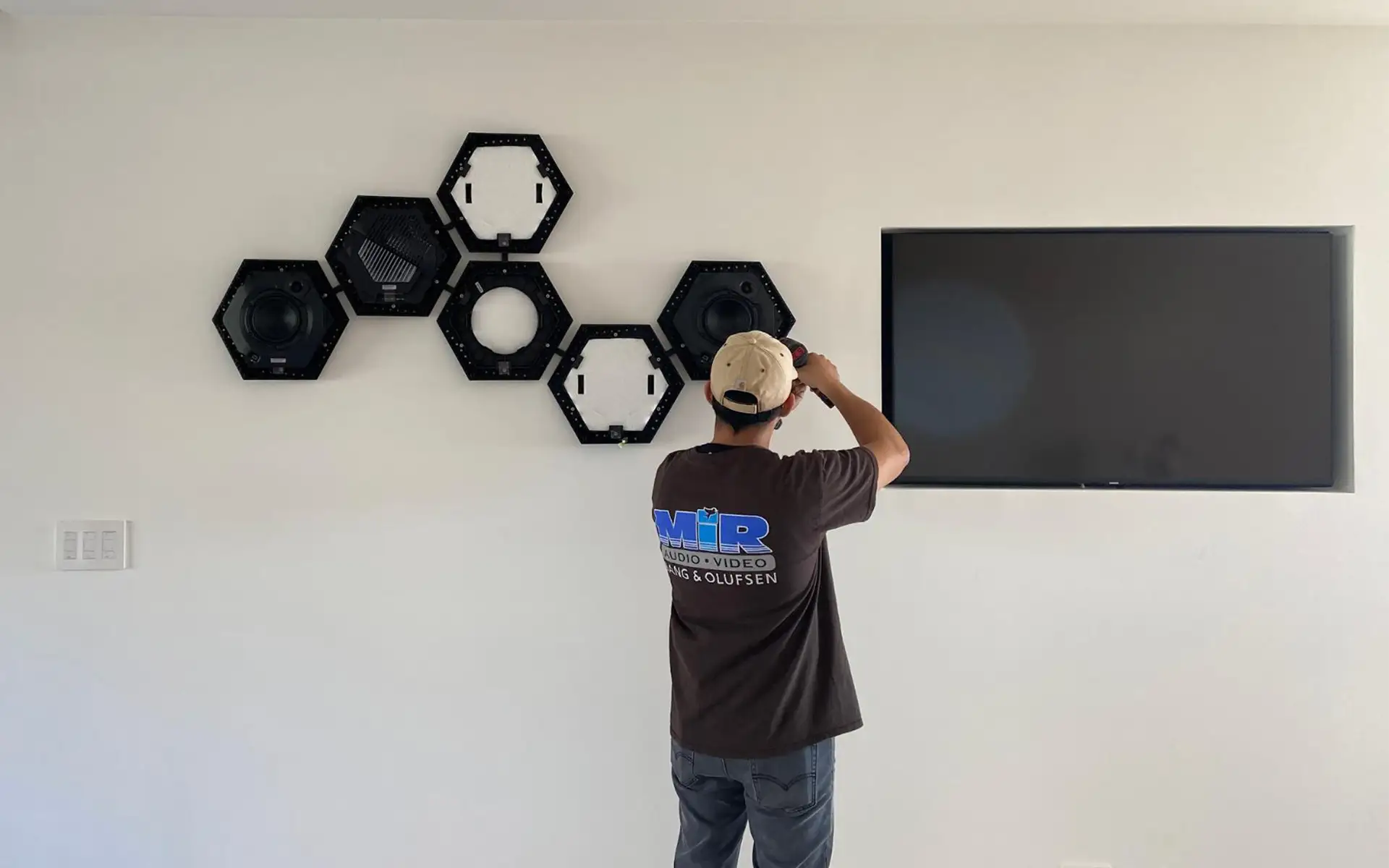 A MIR Audio Video insured AV installer in Los Angeles installs an intricate wall-mounted speaker system inside a home