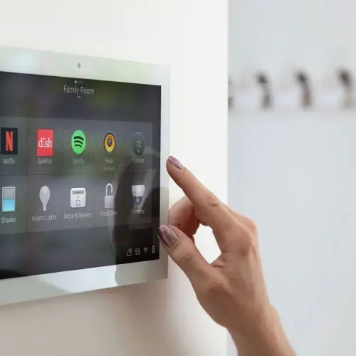 A woman interacts with her Control4 system using a wall-mounted control panel