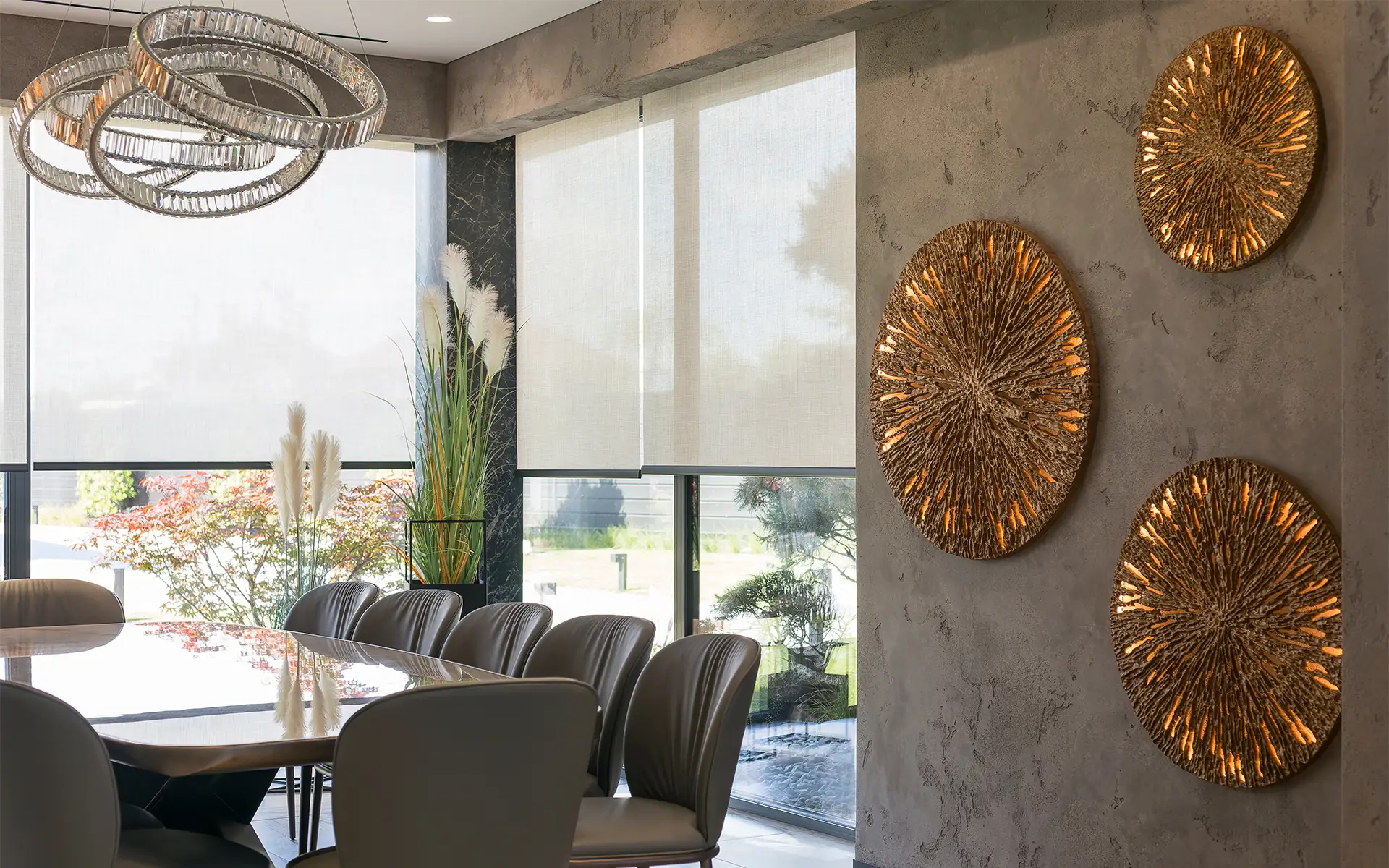 A modern dining room with floor-to-ceiling windows featuring automated window shades lowered halfway