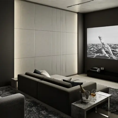 A luxury home theater room done in greys with multi-level seating and a modern, fabric-covered speaker wall